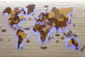 Wooden decorative world map with purple neon backlight on apartment wall. Modern interior design. © Olena Seiryk