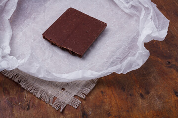 Porous chocolate bar on white paper. Bubbled or spongy chocolate, tasty sweets, carbohydrate food,...