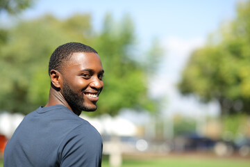 Happy black man looking at camera in a park