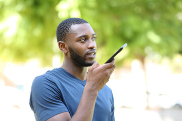 Black man dictating audio message on smart phone
