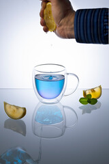 Glass cup of organic blue Anchan on light table. Herbal tea
