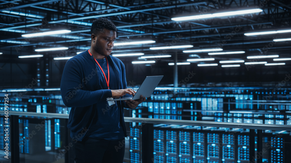 Fototapete portrait of a data center engineer using laptop computer. server room specialist facility with afric