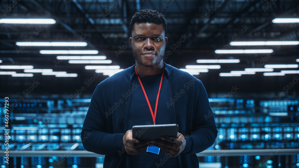 Poster Portrait of a Data Center Engineer Using Laptop Computer. Server Room Specialist Facility with Black Male System Administrator Working with Data Protection Network for Cyber Security.