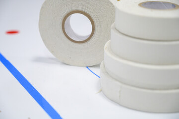 Selective focus closeup of an ice hockey analytics chart with rolls of racket tape