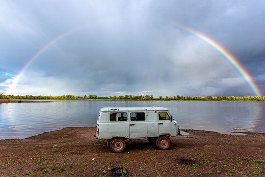 Russian UAZ bellow the rainbow near the river