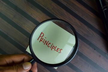 Principles write on sticky notes isolated on Wooden Table.