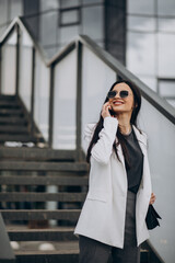 Young business woman talking on the phone in the street