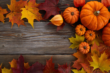 Framework with pumpkins and fall leaves on wooden background. Top view.