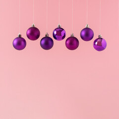Creative composition made of purple christams balls on pink background. Minimal Christmas, winter, New Year concept. Copy space.