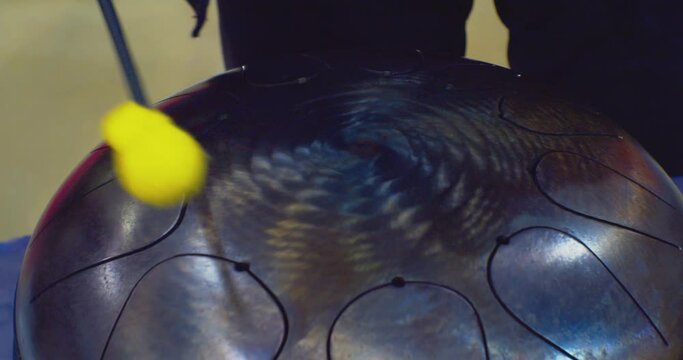 hobbies and leisure. the drummer plays a handpan metal drum. close-up.