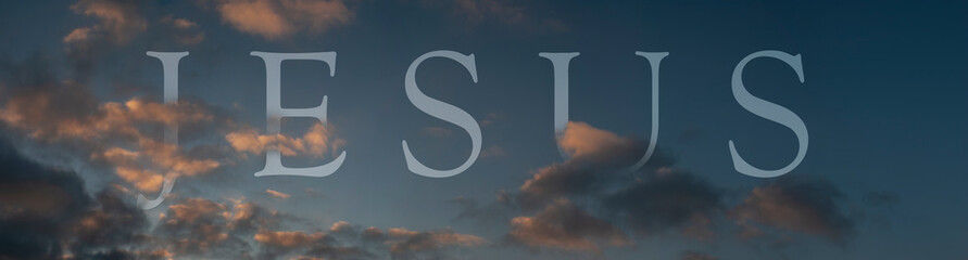 Abstract religious concept. The name of Jesus in the air. Symbolic word inscibed amongst clouds on the evening sky.