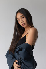 Naklejka premium Attractive asian woman in jacket posing on white background.