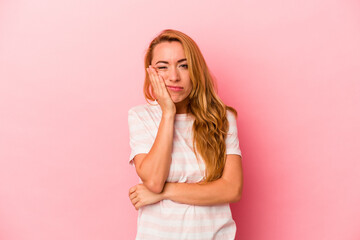 Caucasian blonde woman isolated on pink background who is bored, fatigued and need a relax day.