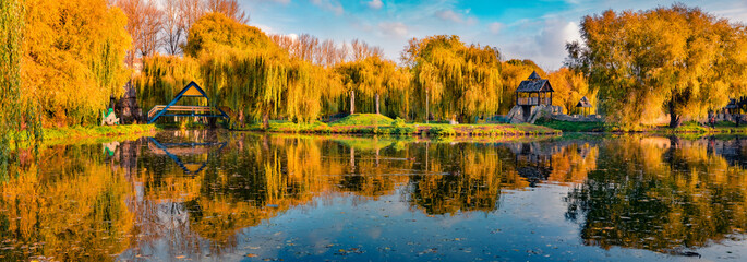 Sunny autumn scene of city park. Panoramic morning view of orange trees in Ternopil square, Ukraine, Europe. Beauty of nature concept background.