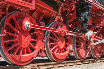 Rote Räder und Antriebsstangen einer historischen Dampflokomotive auf Schienen, Nahaufnahme, Emden, Ostfriesland, Niedersachsen, Deutschland 
