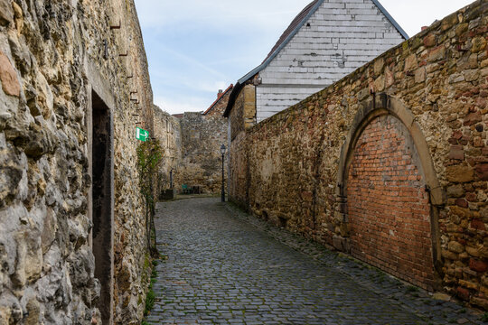 Gasse mit Kopfsteinpflaster und historischer Stadtmauer in der Altstadt von Freinsheim, Rheinland-Pfalz, Deutschland