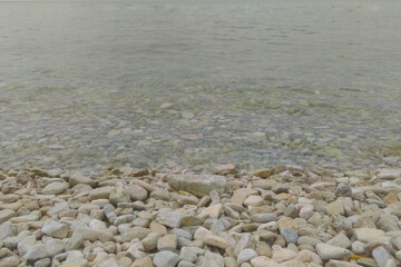 The coast of the sea or ocean with stones and clear water.