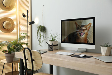Comfortable workplace with computer in light room. Interior design
