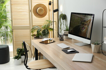 Comfortable workplace with computer in light room. Interior design