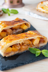 Homemade Peach Strudel for breakfast in the kitchen. Slices of Brown Juicy Cake with southern fruit for dessert.