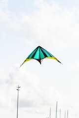 Green, black and yellow kite flying over the sky.