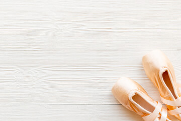 Pair of beige ballet pointe shoes with ribbon, top view