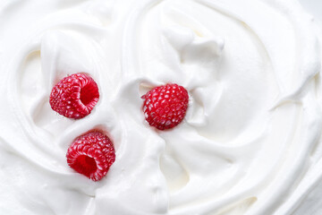 Fresh raspberries in the yoghurt or cream. Top view.