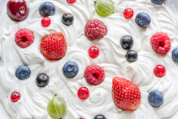 Mix of fresh berries in the yoghurt or cream. Top view.