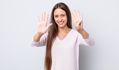hispanic pretty woman smiling and looking friendly, showing number nine or ninth with hand forward,...
