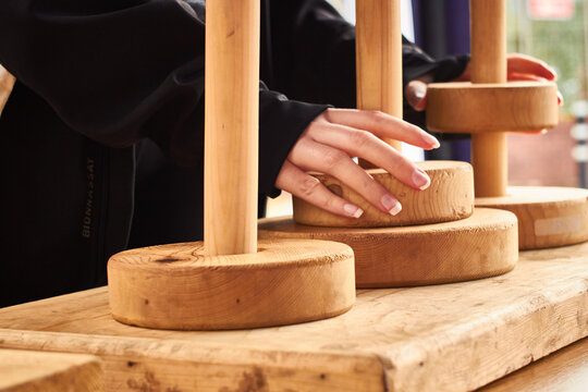Closeup of white woman hands solving the tower of Hanoi puzzle ring stack game