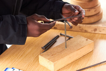 Closeup of black man hands playing solving nail balancing puzzle game 