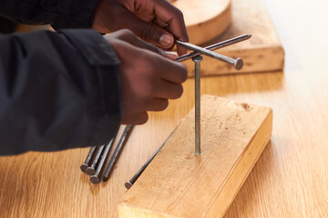 Closeup of black man hands playing solving nail balancing puzzle game 