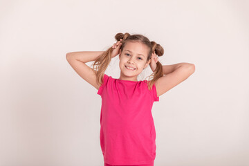 happy child on a white background. a girl in a pink T-shirt and pants.