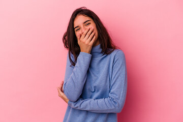 Young caucasian woman isolated on pink background laughing happy, carefree, natural emotion.