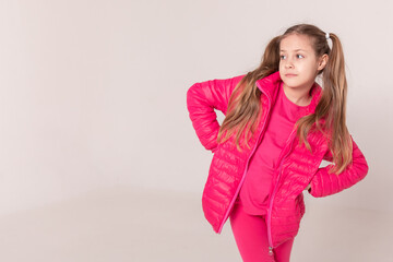 girl with tails on a white background. baby in a pink jacket