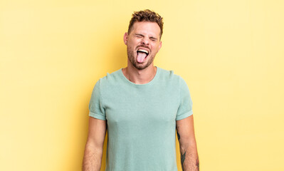 young handsome hispanic man with cheerful, carefree, rebellious attitude, joking and sticking...
