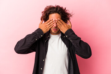 Young caucasian man isolated on pink bakcground afraid covering eyes with hands.