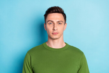 Photo of calm focused concentrate handsome man look camera wear green sweater isolated blue color background