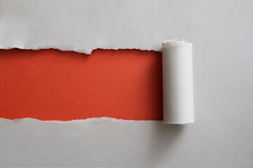 Red banner framed by torn grey paper rolled back