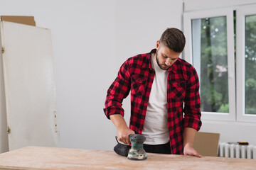 close up of man working with electric sander