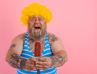 Fat amazed man with beard and wig eats a popsicle