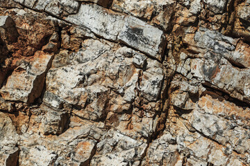 Grungy cragged bumpy pitted cavity stone facade, split layer gap.Ruined cracked shattered worn rough hiking canyon.Old ragged grunge steep marble cliff. Grand vintage crannied damaged impressive gorge