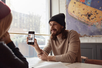 Man show to girlfriend her photo on mobile phone