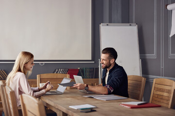 Business man giving copybook to business woman
