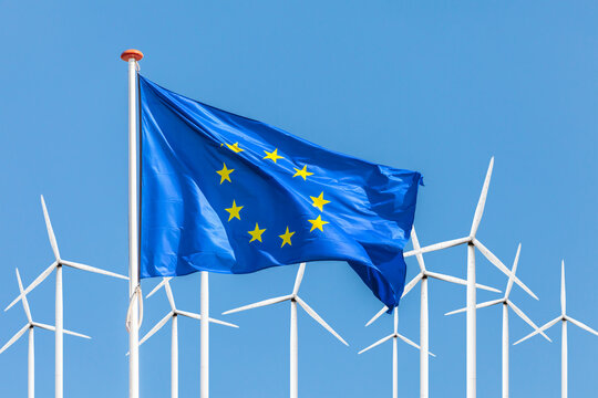 Flag of the European Union in front of a large windpark with wind turbines - Powered by Adobe