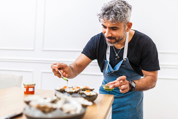 Latin cook cooking oysters with trout roe and coriander oil. Chef preparing food for a private...