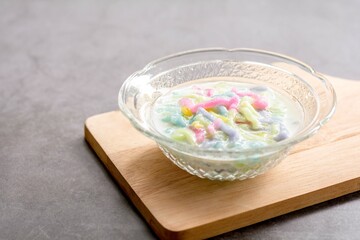 Thai dessert. Colorful of cendol with coconut milk in a clear bowl on a dark table. Delicious famous sweet dish in Thailand.