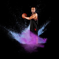 High jumping. Young man, a male basketball player in explosion of colored powder