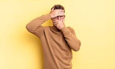 young handsome hispanic man covering face with both hands saying no to the camera! refusing...