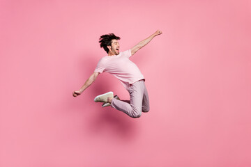 Full length body size man jumping up crazy overjoyed isolated pastel pink color background